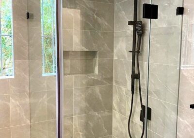 a bathroom with a glass shower door and shower niche