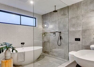 a modern bathroom with a glass shower, niche and tub.