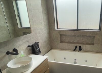 a bathroom with a bathtub, nice, sink and window.