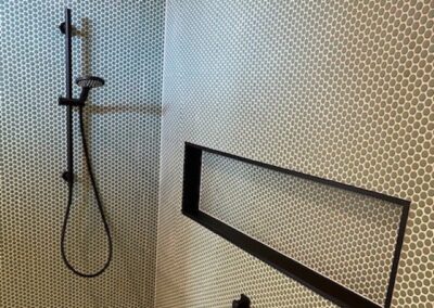 tiled bathroom with black shower niche
