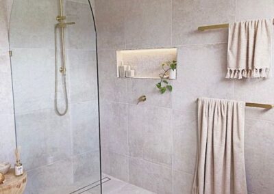 a bathroom with plants on the shower niche and a glass shower stall